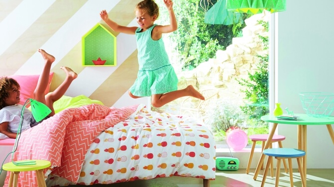 Criança pulando na cama