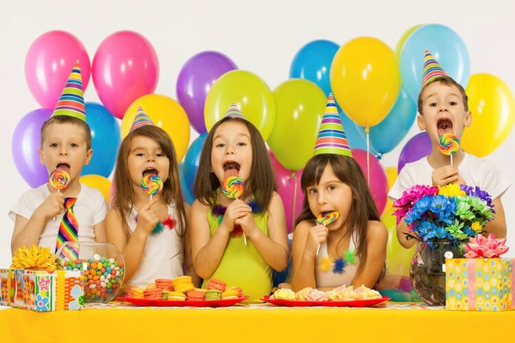 crianças na frente de mesa de festa infantil