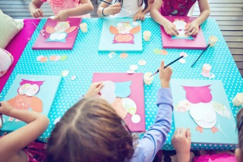 Crianças pintando e desenhando em festa infantil