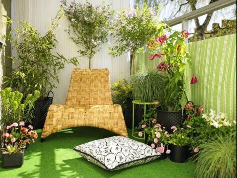 Jardim com grama sintética e cadeira de madeira