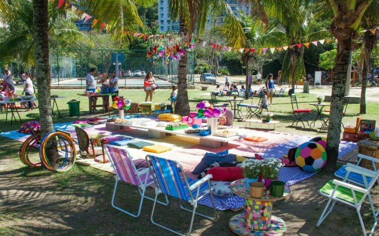 Ambiente em parque decorado para festa de aniversário com bandeirinhas, toalhas e itens coloridos.