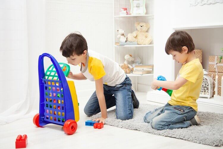 Crianças recolhendo brinquedos no quarto