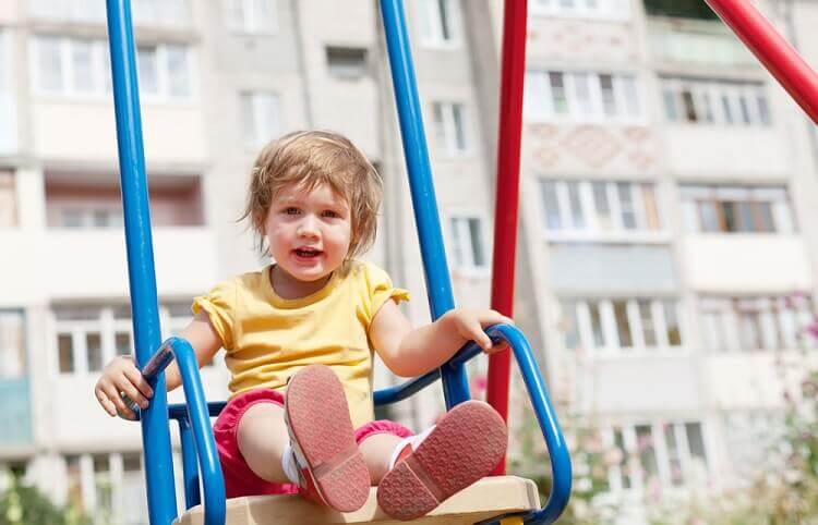 Criança brincando em balanço de playground 3 em 1